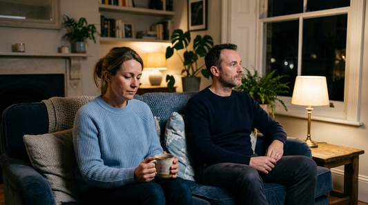 Tired couple sitting quietly on the sofa together in the evening