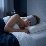 Woman sleeping on The Sana Pillow wearing The Sana Sleep Mask
